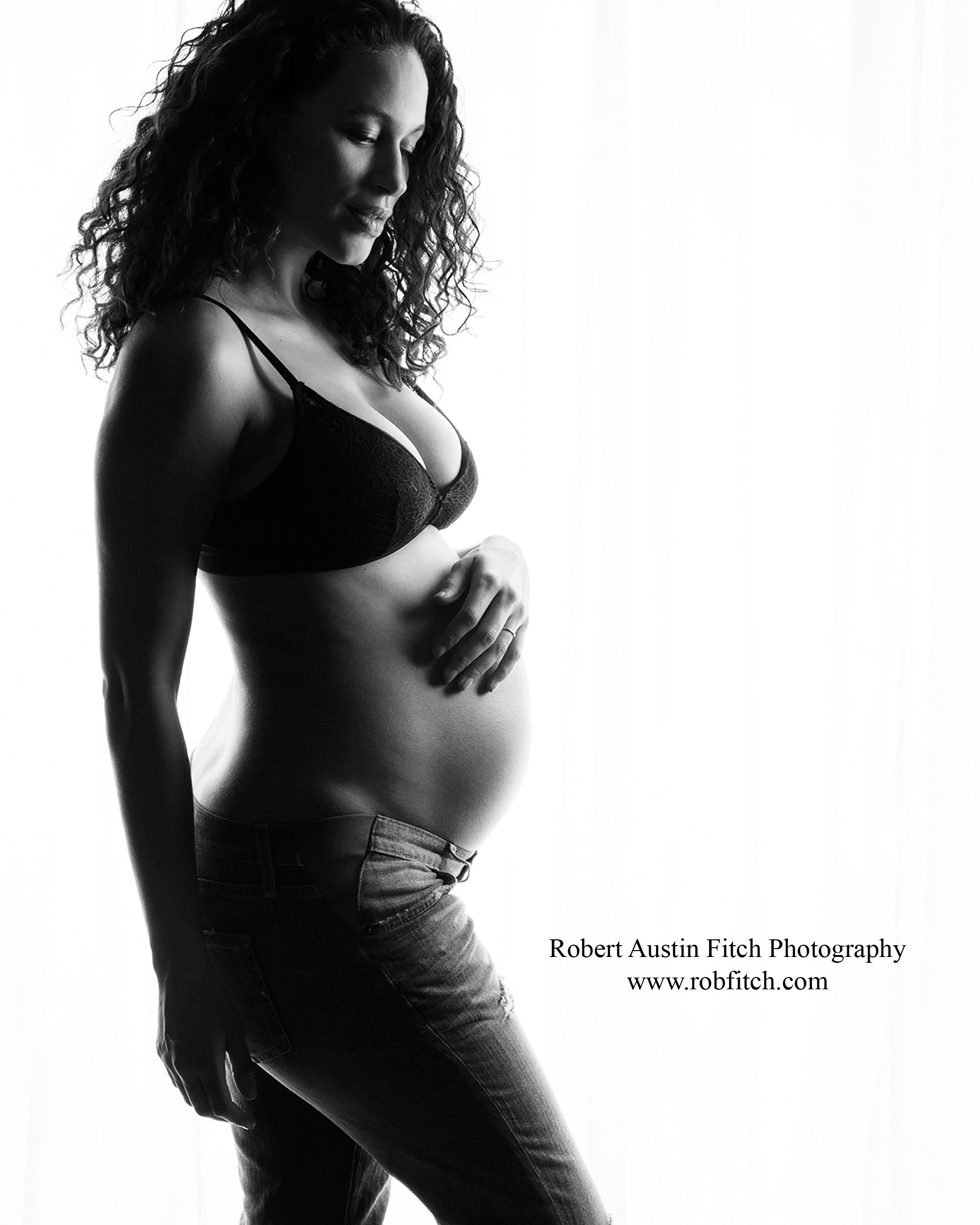 Silhouette maternity photo of pregnant woman wearing jeans and a jog top